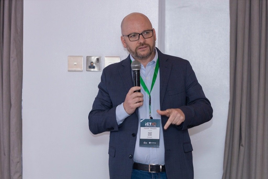Yazeed Sheqem speaking with a microphone at ICT4D 2026